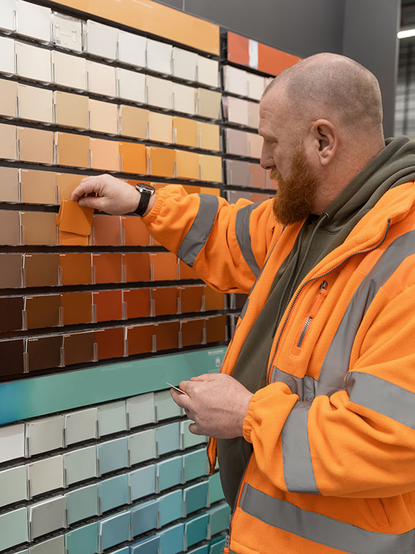 Technician selecting powder coating samples to achieve accurate custom colour matching.