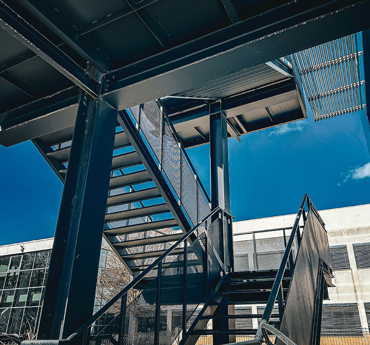 Exterior steel staircase and framework finished with powder coating for durability and corrosion protection.